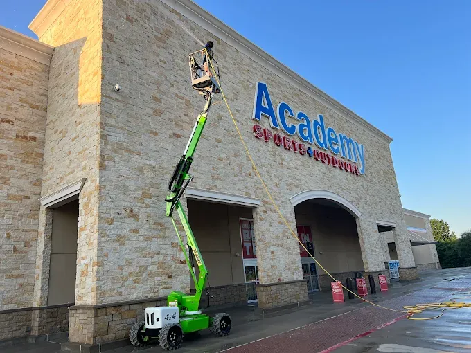 Surface Pro Power Wash cleaning the Academy Sports building exterior with a boom lift in Allen, TX