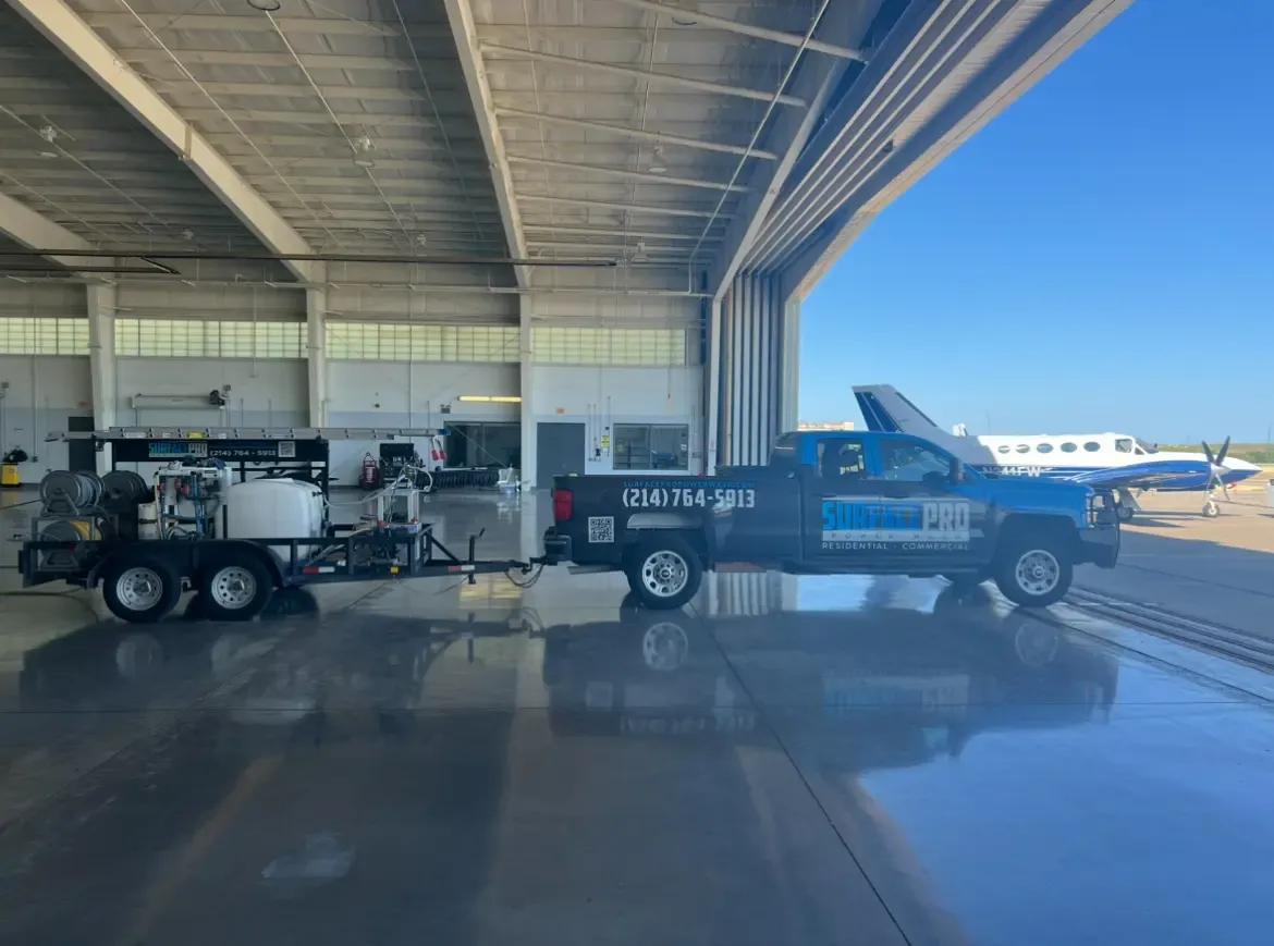 Pressure washing truck and trailer on a freshly cleaned aircraft hangar floor in Frisco, TX