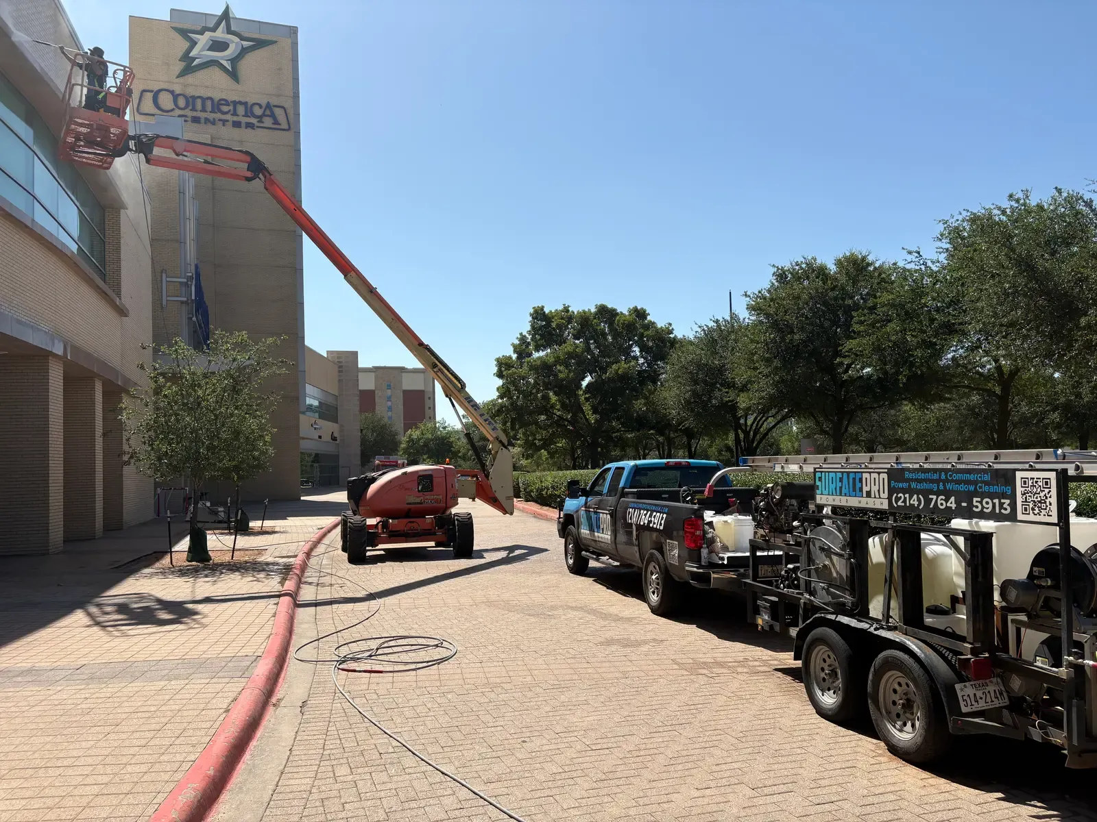 Surface Pro Power Wash truck, trailer rig, and boom lift cleaning the Comerica Center arena exterior in Frisco, TX