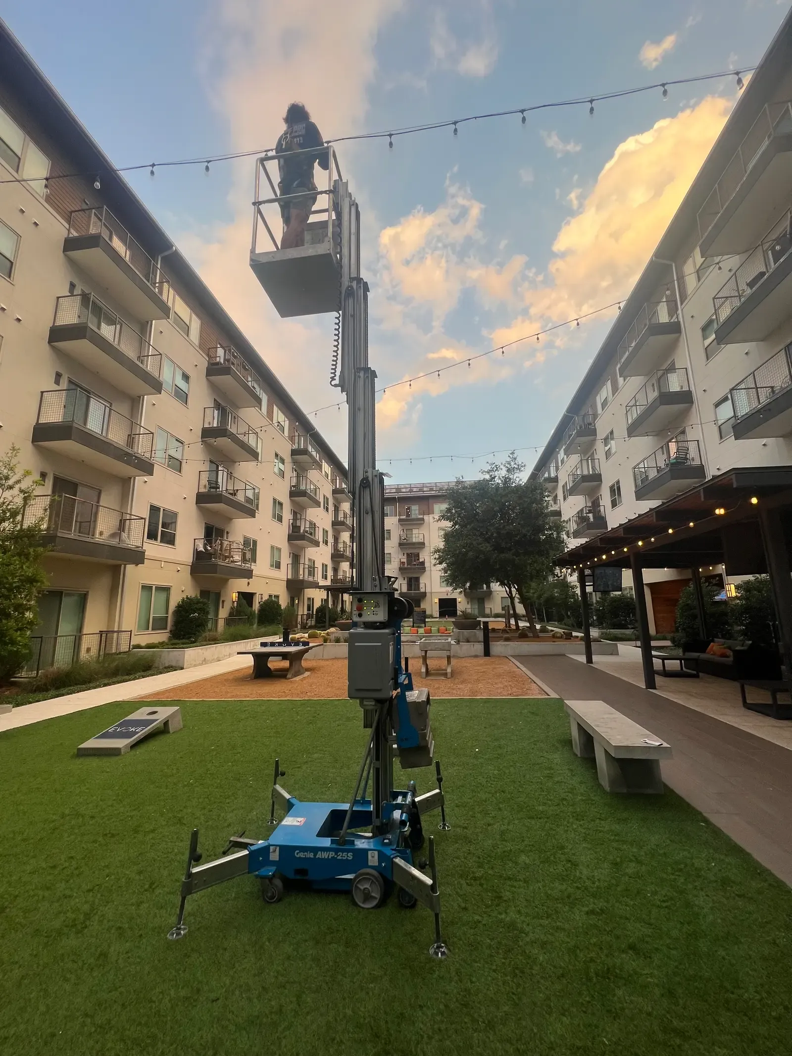 Personnel lift raised in an apartment courtyard for high exterior cleaning work in Frisco, TX