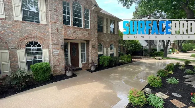 Freshly pressure washed driveway at a two-story brick home in Allen, TX