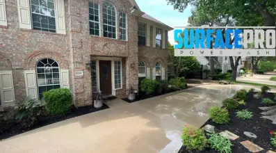 Freshly pressure washed driveway at a two-story brick home in Allen, TX
