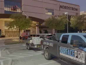 Surface Pro Power Wash washing the upper Nordstrom building exterior from a boom lift in Dallas, TX