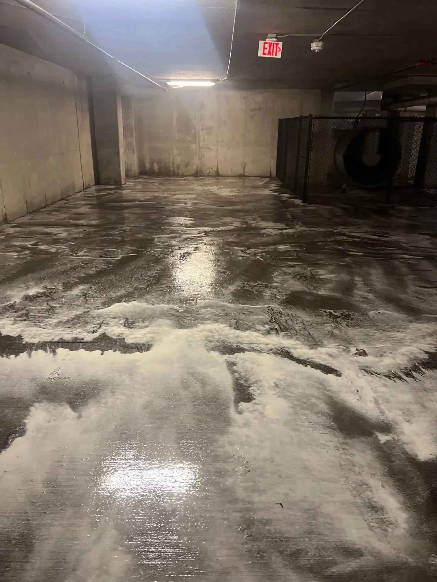 Soap suds dwelling on wet parking garage concrete during a scheduled cleaning in Richardson, TX
