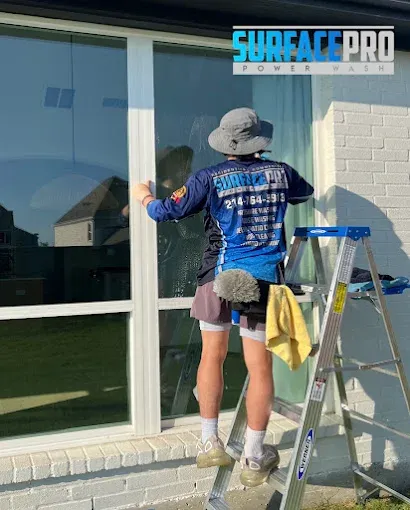 Surface Pro technician cleaning the exterior windows of a home in Allen, TX
