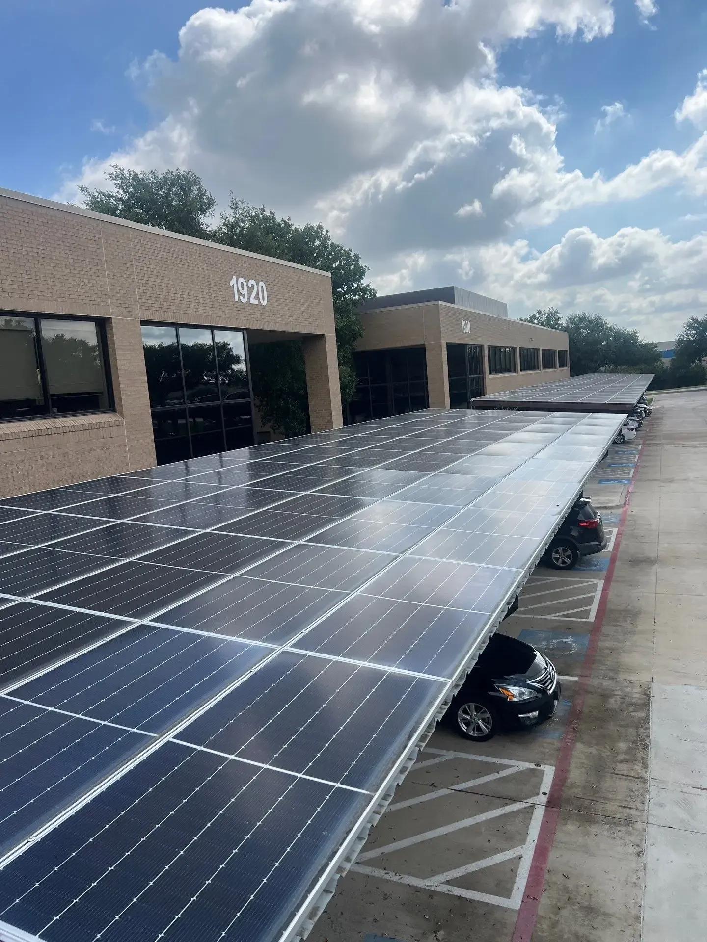 Clean solar panel carport canopies over commercial office parking after panel washing in Plano, TX