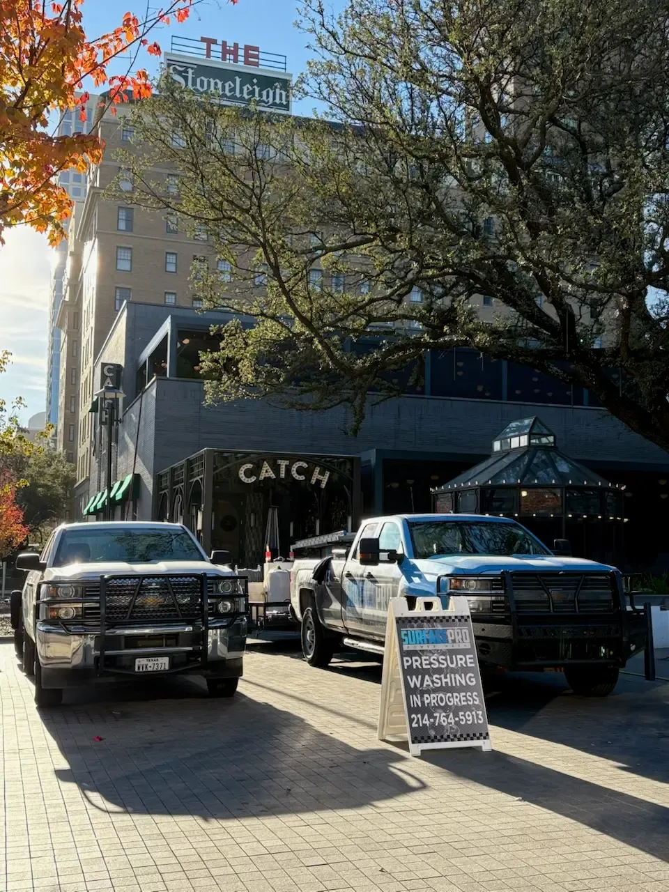 Surface Pro Power Wash trucks cleaning the streetscape outside the Stoneleigh hotel in Dallas, TX