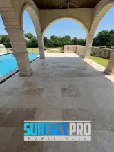 Cleaned travertine patio overlooking a backyard pool in Frisco, TX