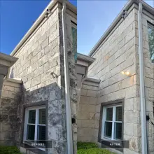 Before and after soft wash of a two story limestone wall with gray biological staining removed in Plano, TX